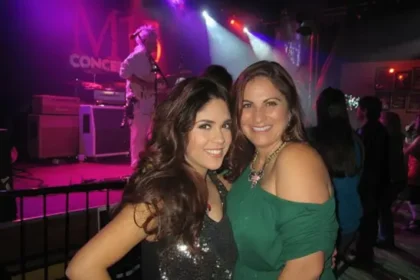 Debra Bollman with her daughter on stage during a concert, smiling and professional.